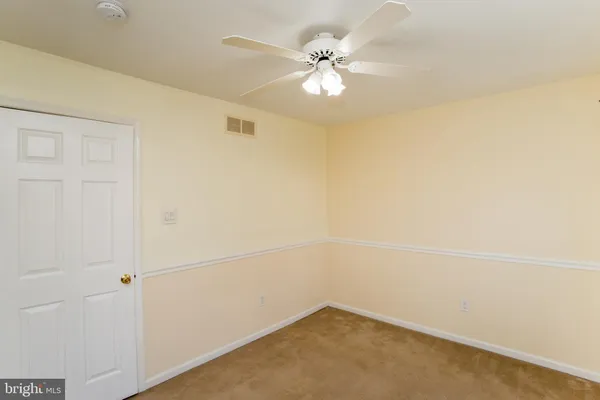 an empty room with a ceiling fan and a window