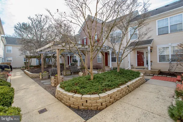 a view of a white house with large windows and a small yard