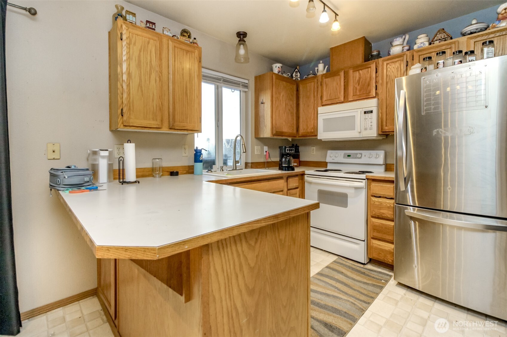 249 South Elsa Street Buckley, WA 98321 - Photo 14 of 37 a kitchen with kitchen island a counter top space a sink stainless steel appliances and cabinets