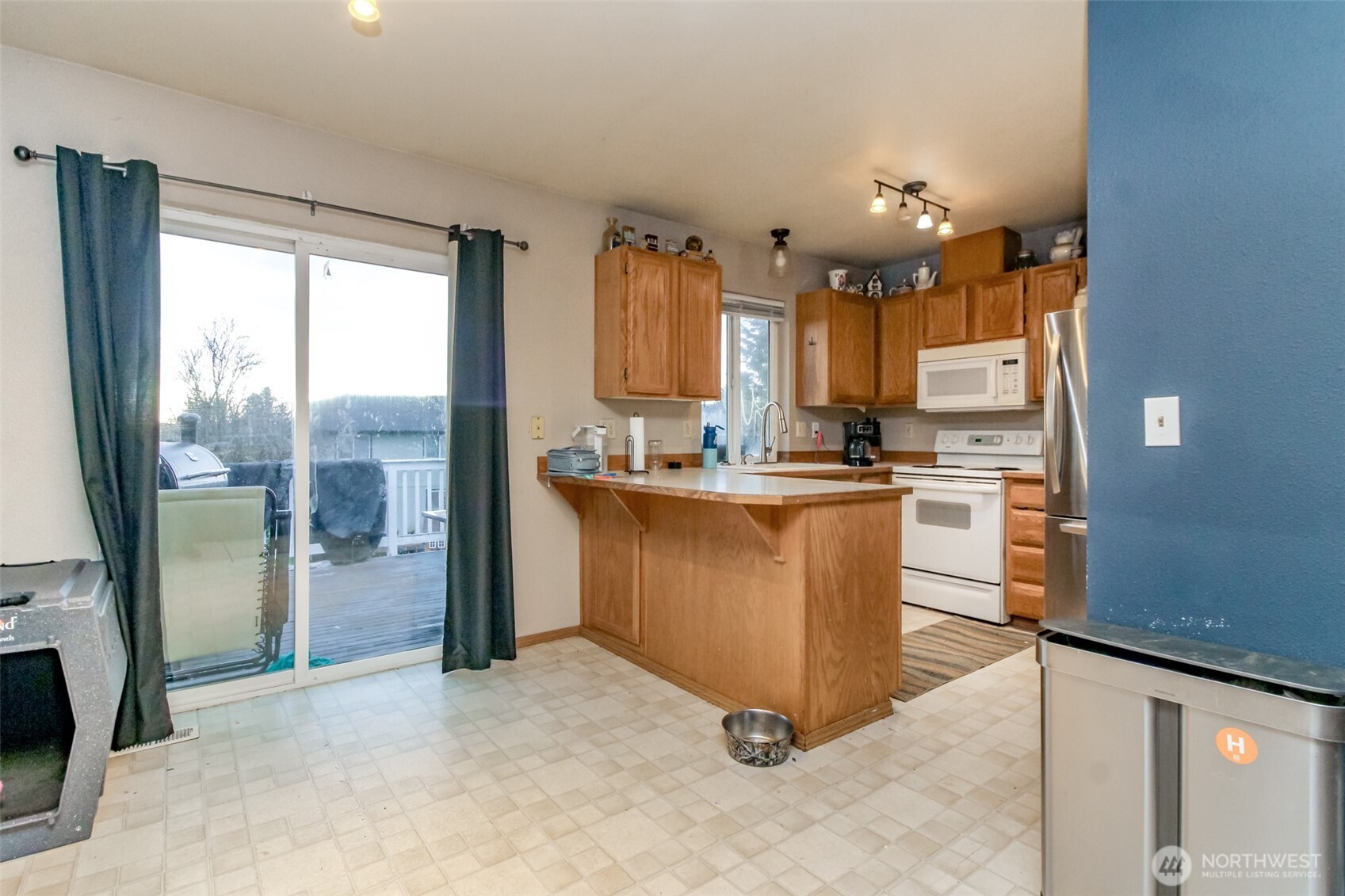 249 South Elsa Street Buckley, WA 98321 - Photo 17 of 37 a kitchen with kitchen island granite countertop a refrigerator a sink a stove and white cabinets