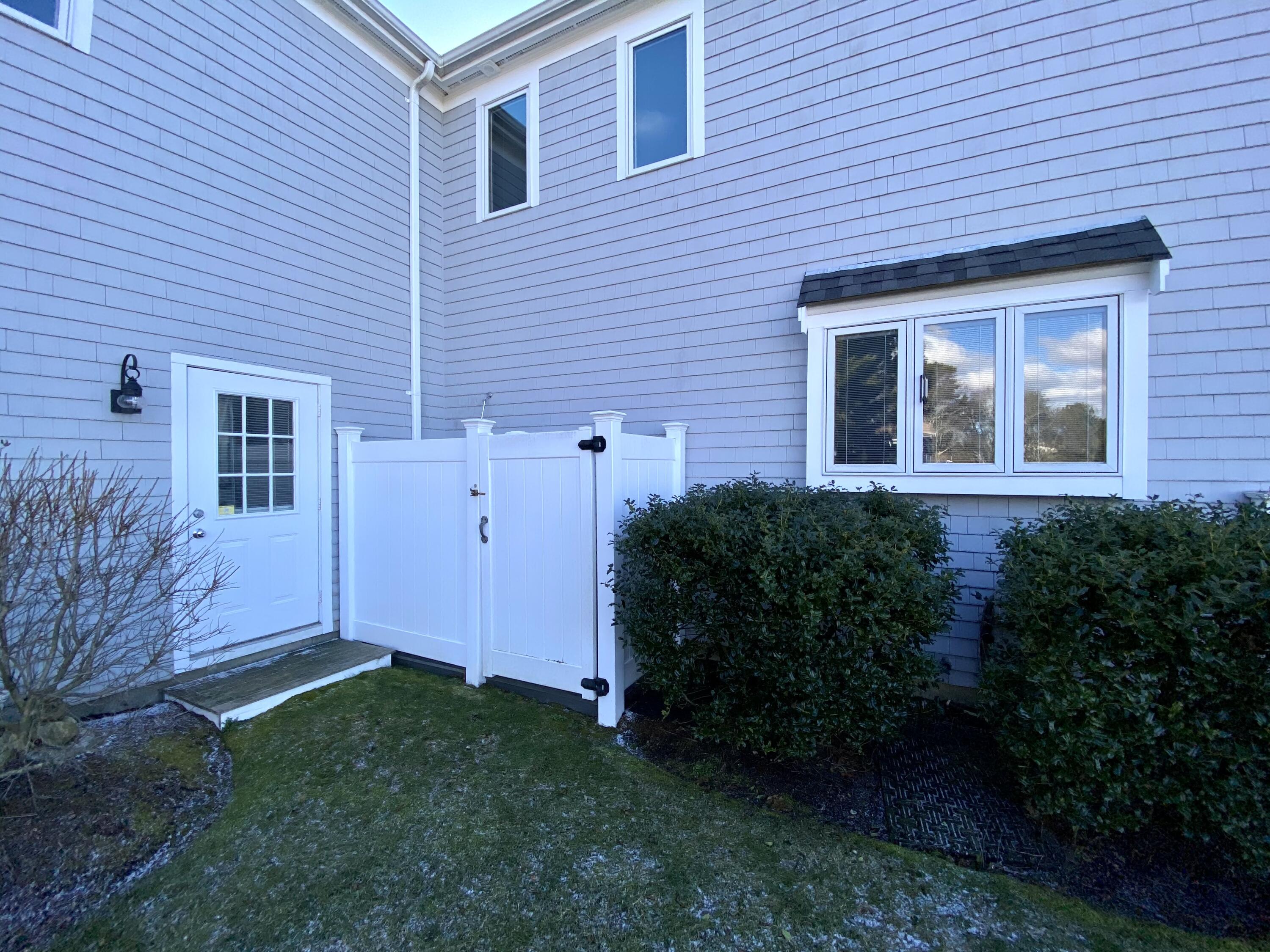 294 Cairn Ridge Road East Falmouth, MA 02536 - Photo 7 of 29 a view of backyard with potted plants and wooden fence