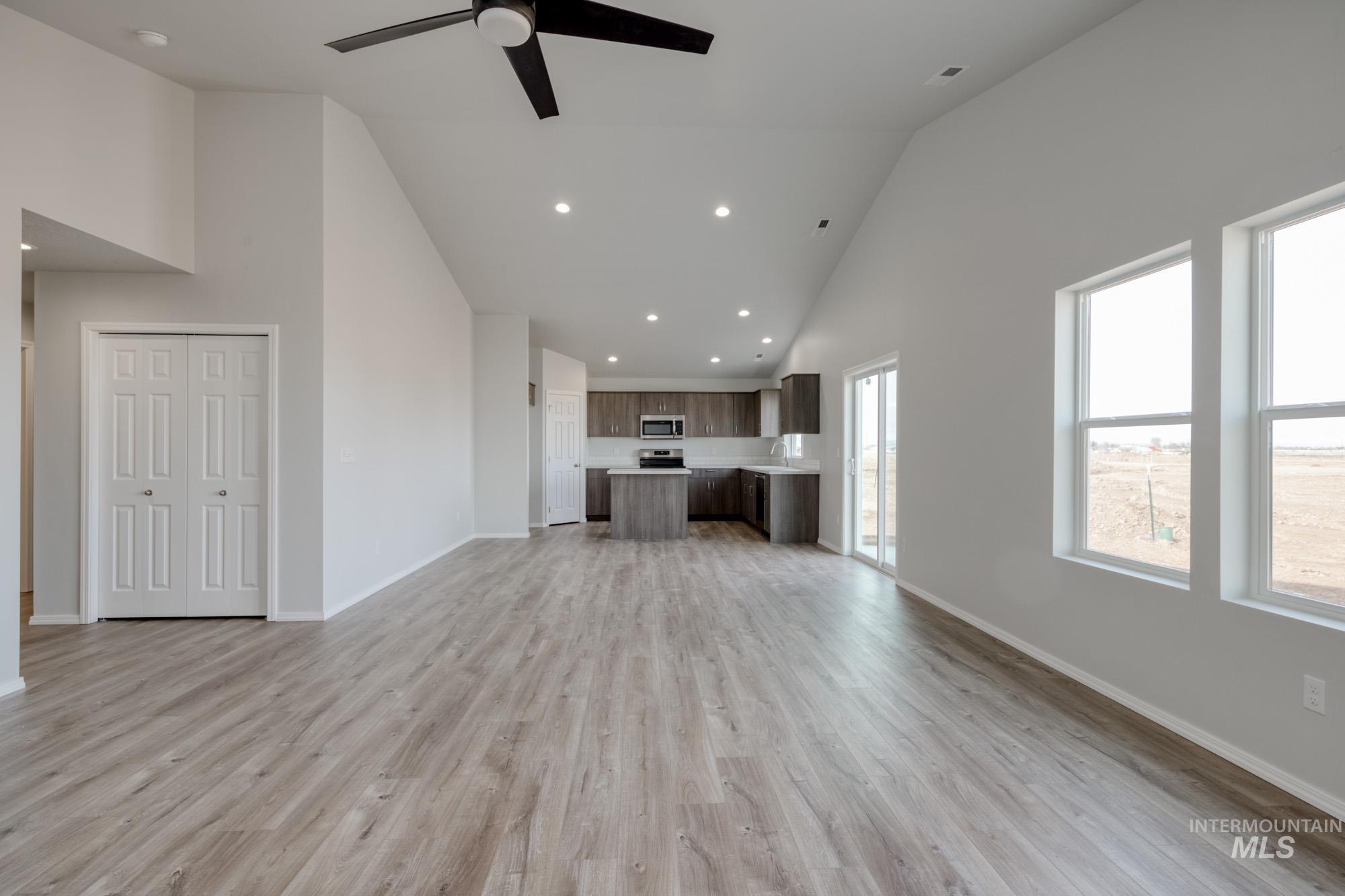 1666 Dyer Street Middleton, ID 83644 - Photo 11 of 22 Unfurnished living room featuring high vaulted ceiling, light wood finished floors, recessed lighting, and ceiling fan