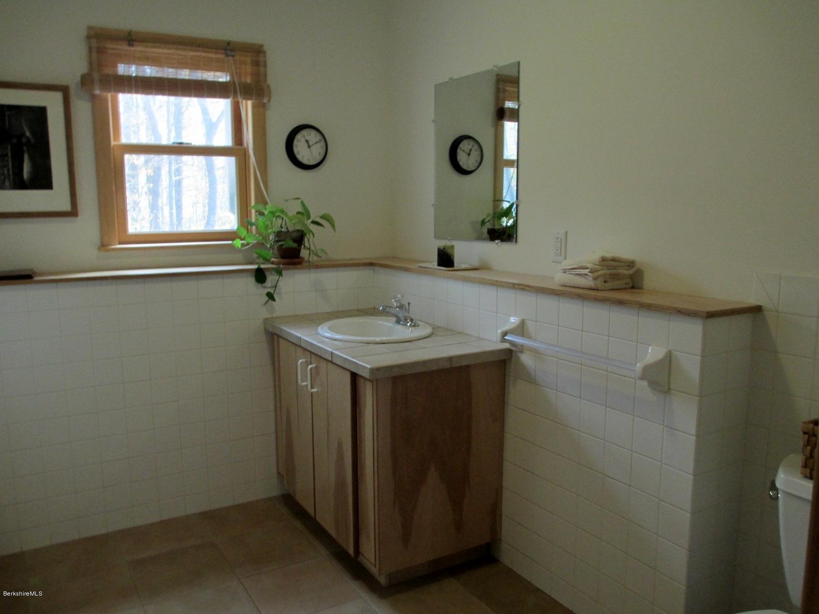 170 Leland Road Becket, MA 01223 - Photo 41 of 59 a bathroom with a granite countertop sink a mirror and a shower