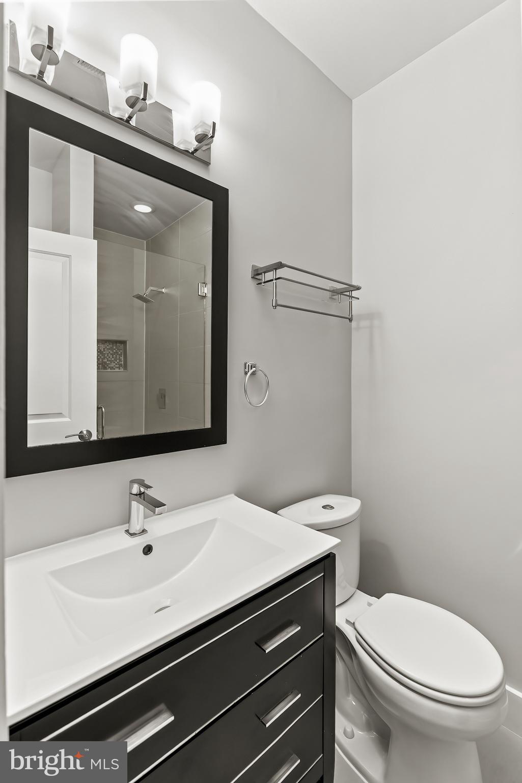 2616 Garfield Street Northwest, Unit 1 Washington, DC 20008 - Photo 12 of 22 a bathroom with a toilet a sink and mirror