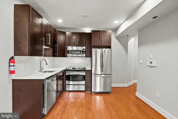 a kitchen with granite countertop a refrigerator and a stove top oven