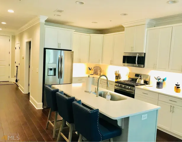 a kitchen with granite countertop a sink stove and refrigerator