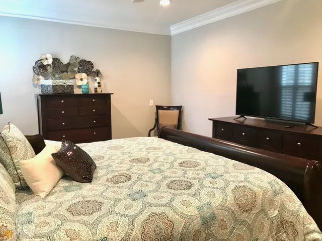 a bedroom with a bed and a flat screen tv
