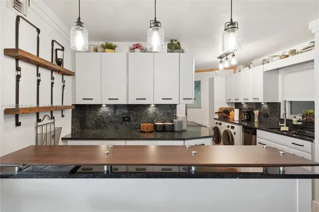 a kitchen with stainless steel appliances granite countertop a sink a refrigerator and a granite counter tops