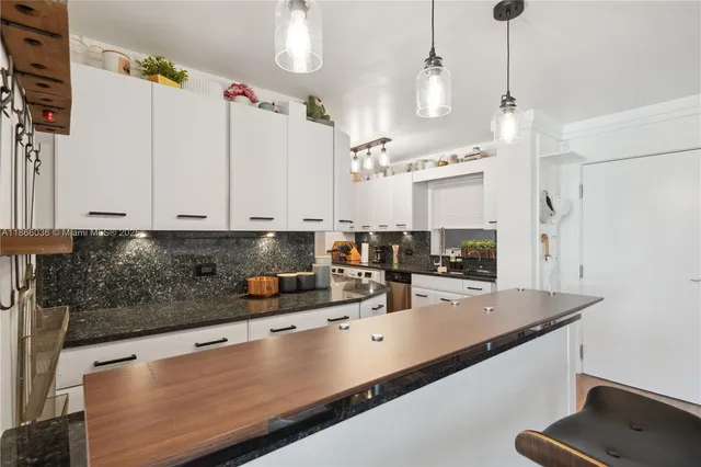 a kitchen with stainless steel appliances kitchen island granite countertop a sink and cabinets
