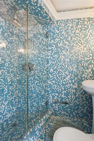 a bedroom with a bed and a large window with view of balcony