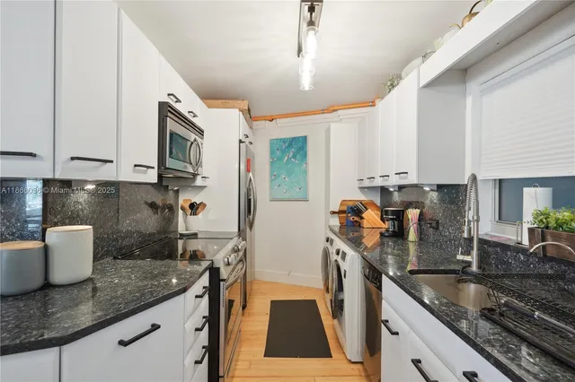 a kitchen with stainless steel appliances granite countertop a sink a stove and a refrigerator