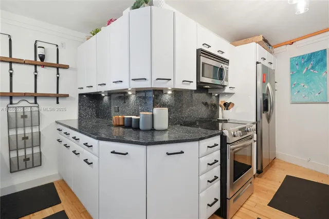 a living room with furniture a flat screen tv and kitchen view
