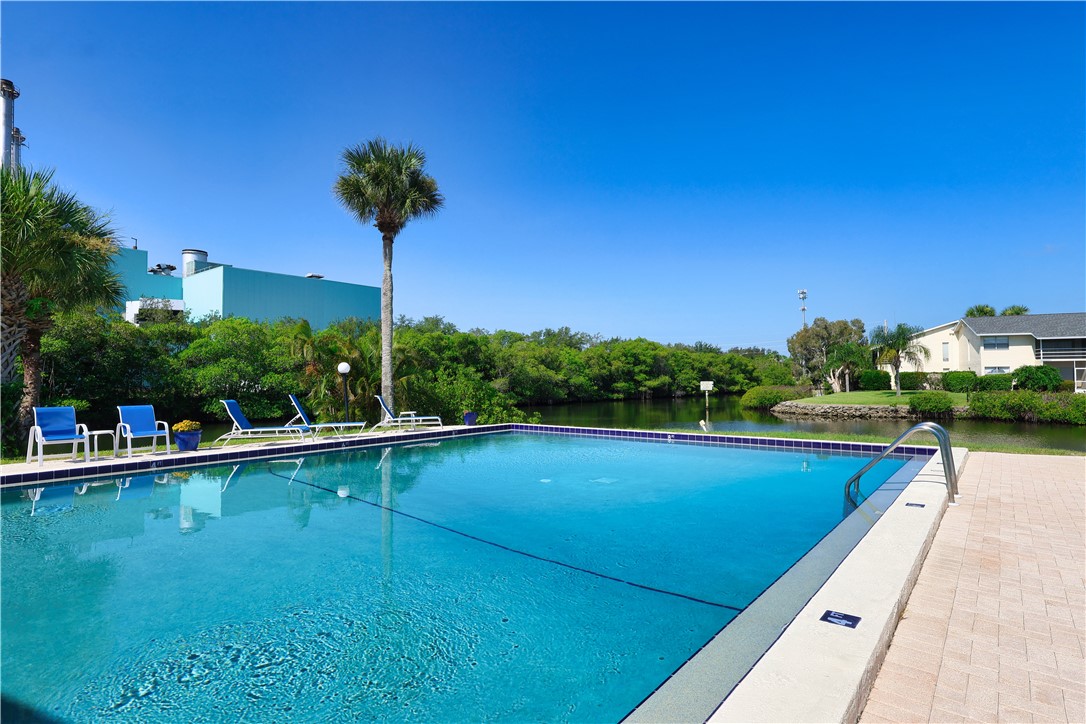 1830 Robalo Drive, Unit B102 Vero Beach, FL 32960 - Photo 23 of 33 a view of a swimming pool and lounge chairs