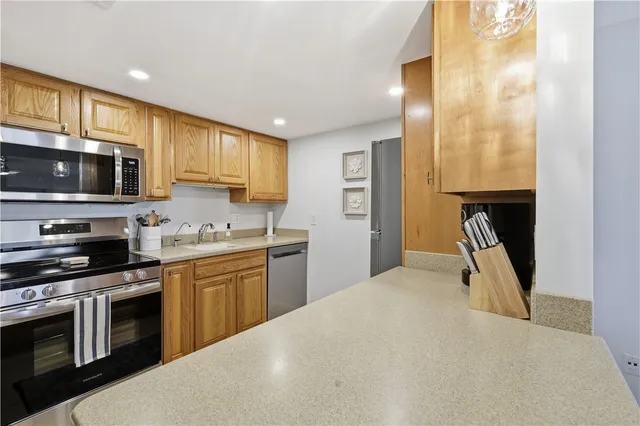 a kitchen with stainless steel appliances granite countertop a stove top oven a sink dishwasher and a microwave oven with white cabinets