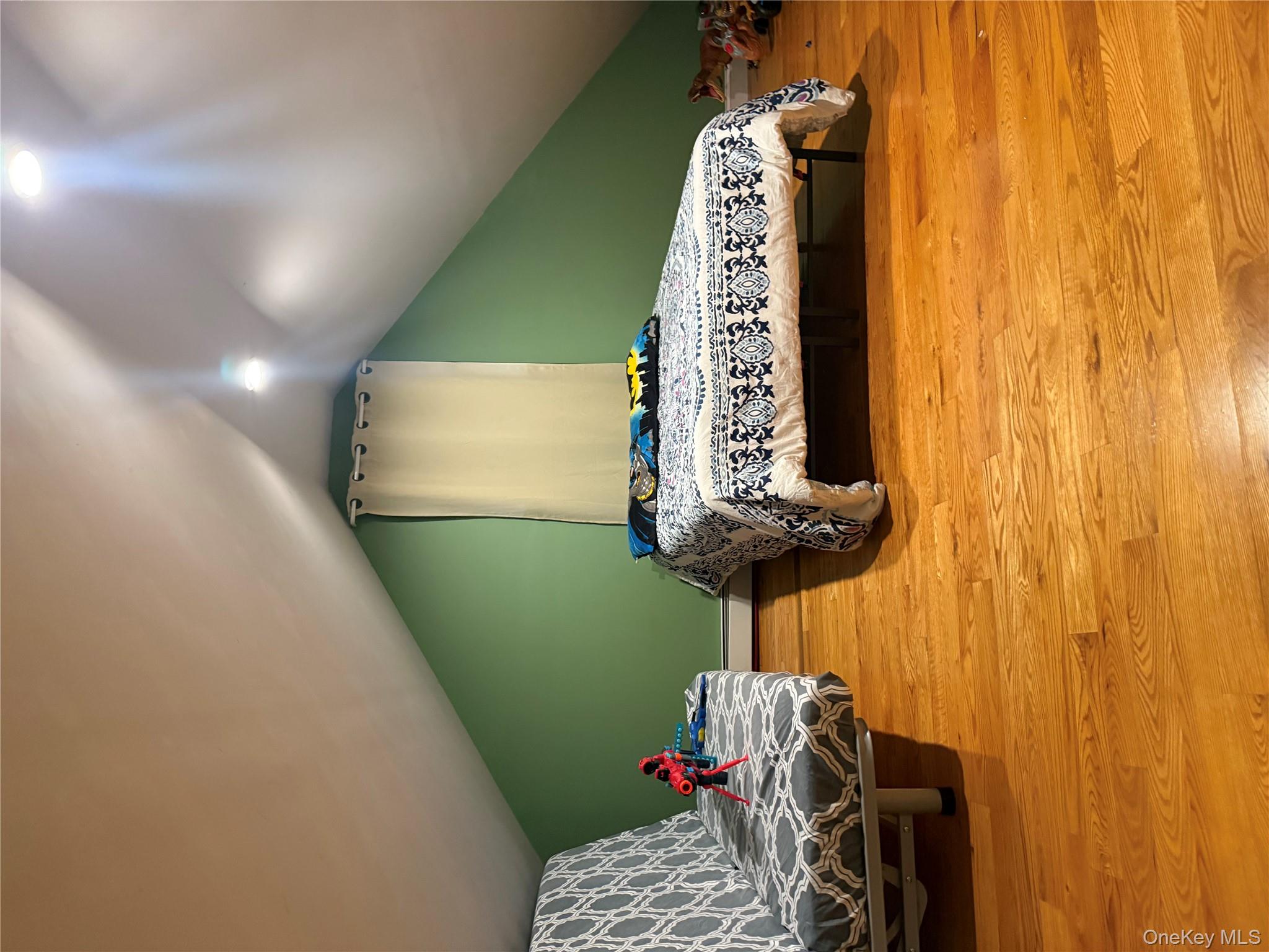 194-56 114th Road Queens, NY 11412 - Photo 11 of 16 a bedroom with a bed and a chandelier