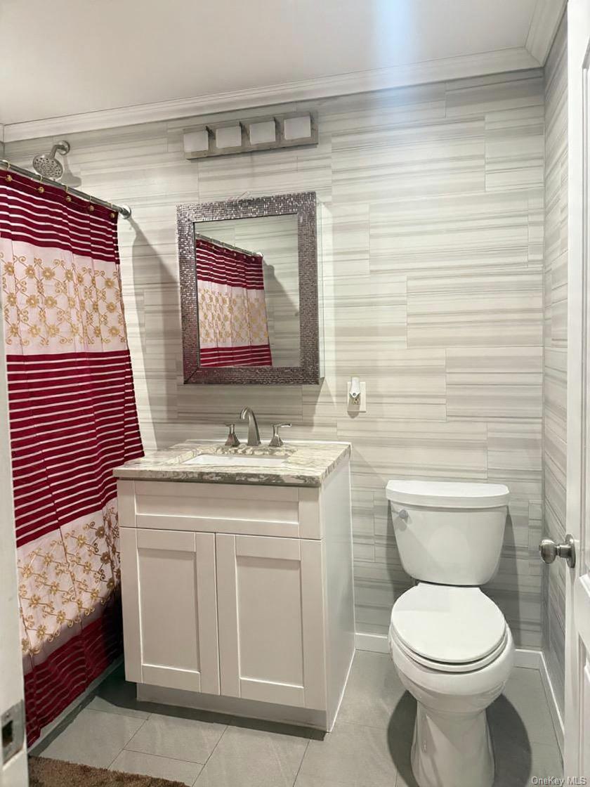 194-56 114th Road Queens, NY 11412 - Photo 12 of 16 a bathroom with a toilet a sink and mirror