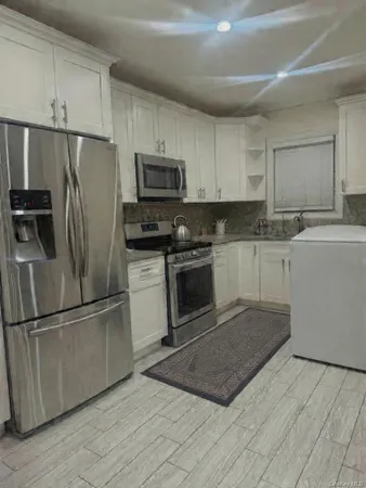 a kitchen with stainless steel appliances granite countertop a refrigerator a stove a sink and a microwave