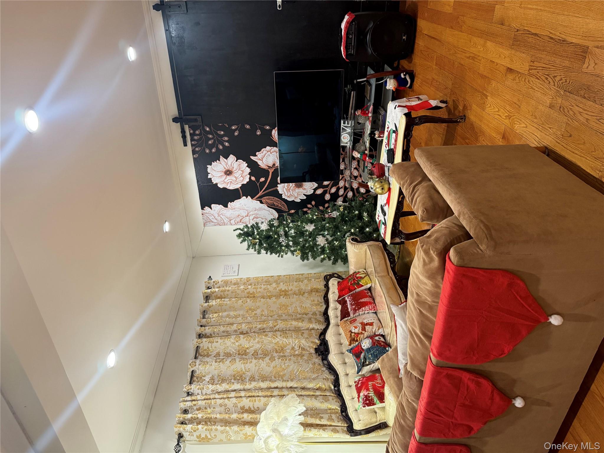 194-56 114th Road Queens, NY 11412 - Photo 5 of 16 a living room with furniture a flat screen tv and a fireplace