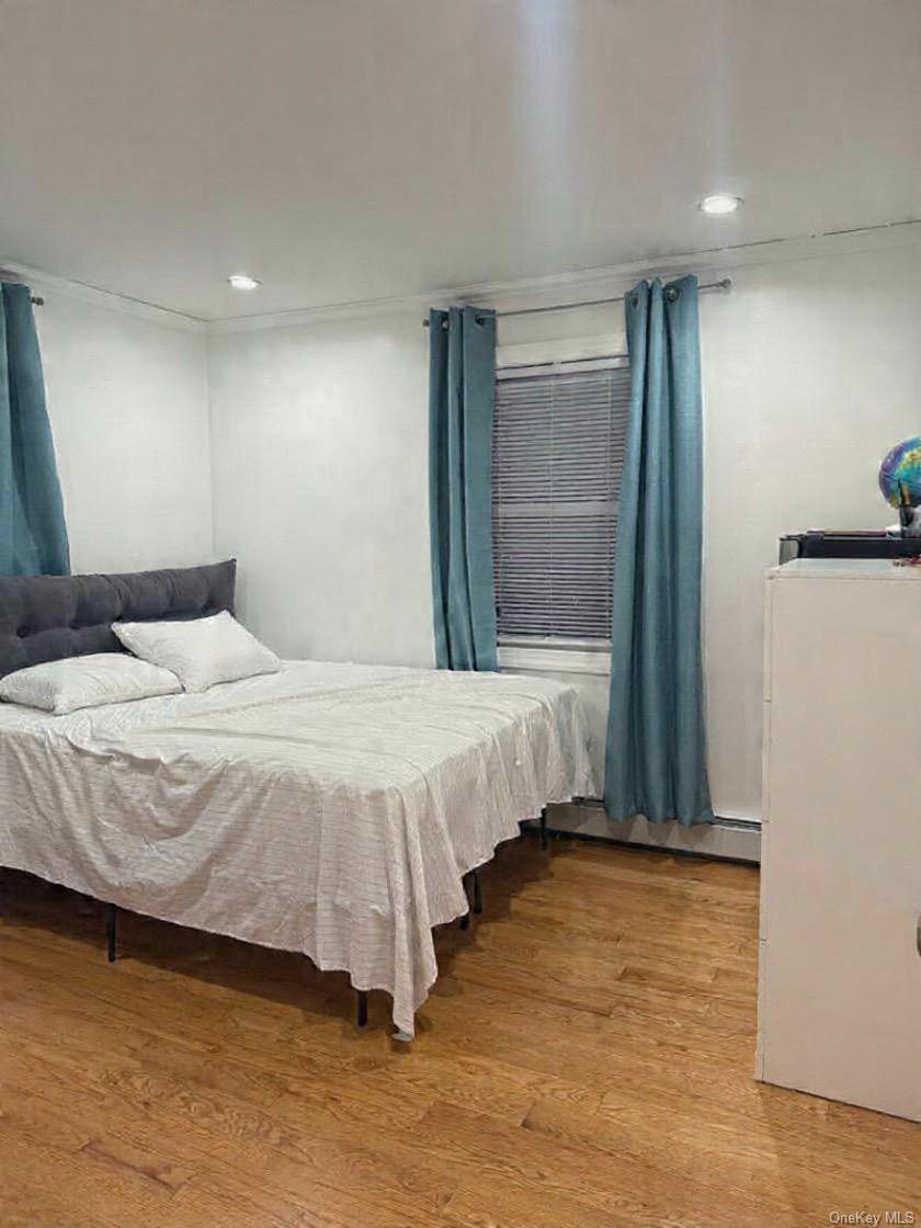 194-56 114th Road Queens, NY 11412 - Photo 9 of 16 a bedroom with a bed and a large window