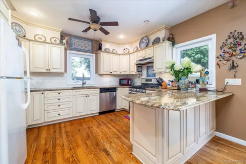 a kitchen with granite countertop a sink appliances cabinets and a counter space