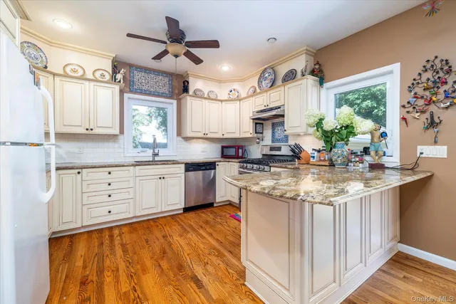 a kitchen with granite countertop a sink appliances cabinets and a counter space