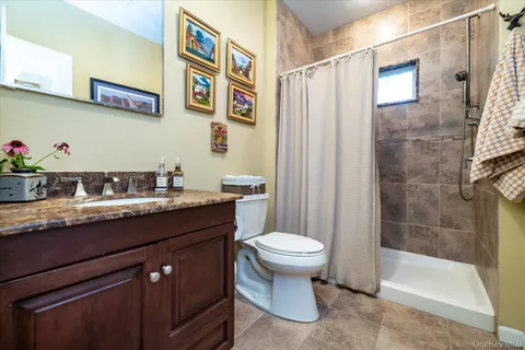 a bathroom with a granite countertop sink toilet and shower