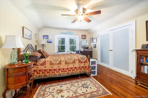 a bed sitting in a bedroom next to a window with a bookshelf and a chandelier
