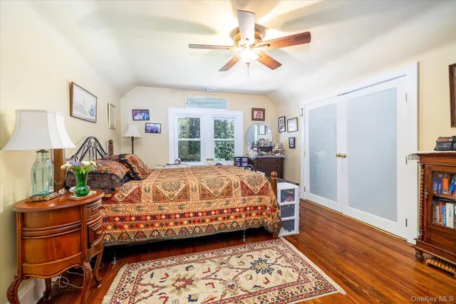 a bed sitting in a bedroom next to a window with a bookshelf and a chandelier