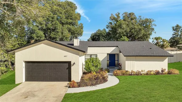 a front view of a house with a garden and yard