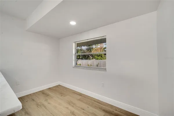 an empty room with wooden floor and window