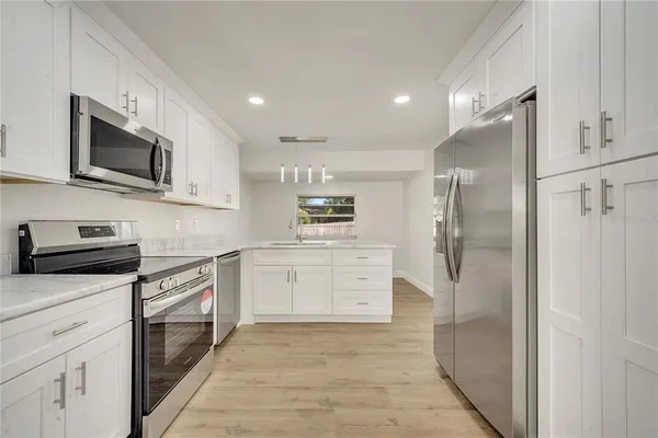 a kitchen with white cabinets stainless steel appliances and a sink