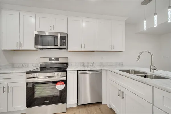 a kitchen with white cabinets and stainless steel appliances