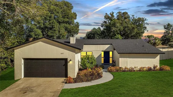 a front view of a house with a garden and yard