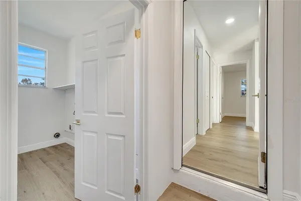 a view of a hallway with wooden floor and staircase