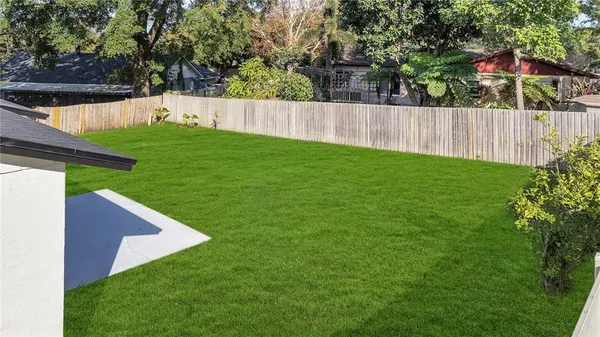 a view of a backyard with a small cabin and wooden fence