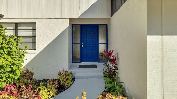 a vase of flowers sitting in front of a door