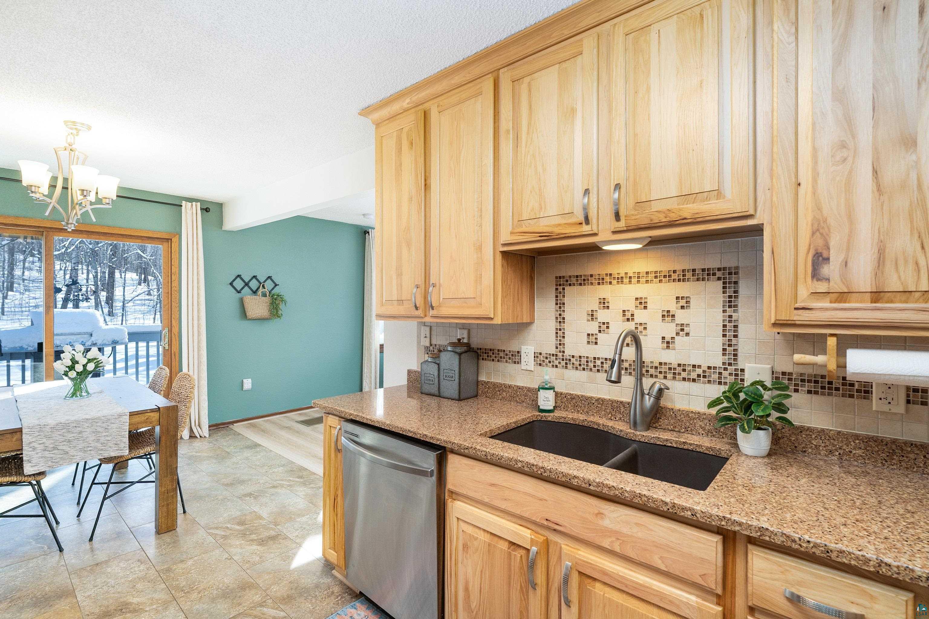 5947 East St Louis River Road Proctor, MN 55810 - Photo 12 of 47 Kitchen with light wood finish cabinetry, a chandelier, dishwasher, decorative backsplash, and a textured ceiling