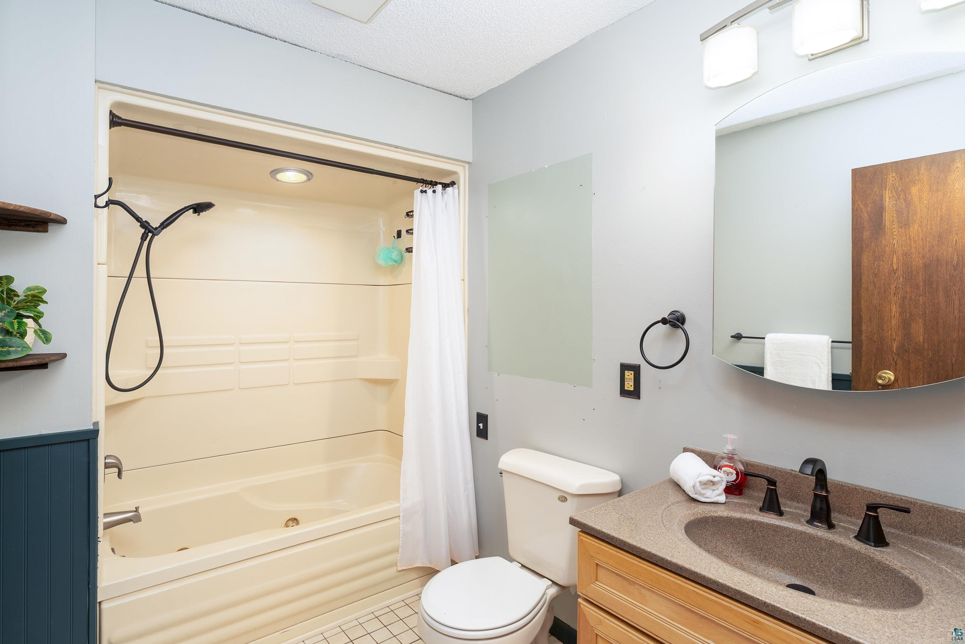 5947 East St Louis River Road Proctor, MN 55810 - Photo 21 of 47 Full bath featuring vanity, shower / bath combination with curtain, and light tile patterned flooring