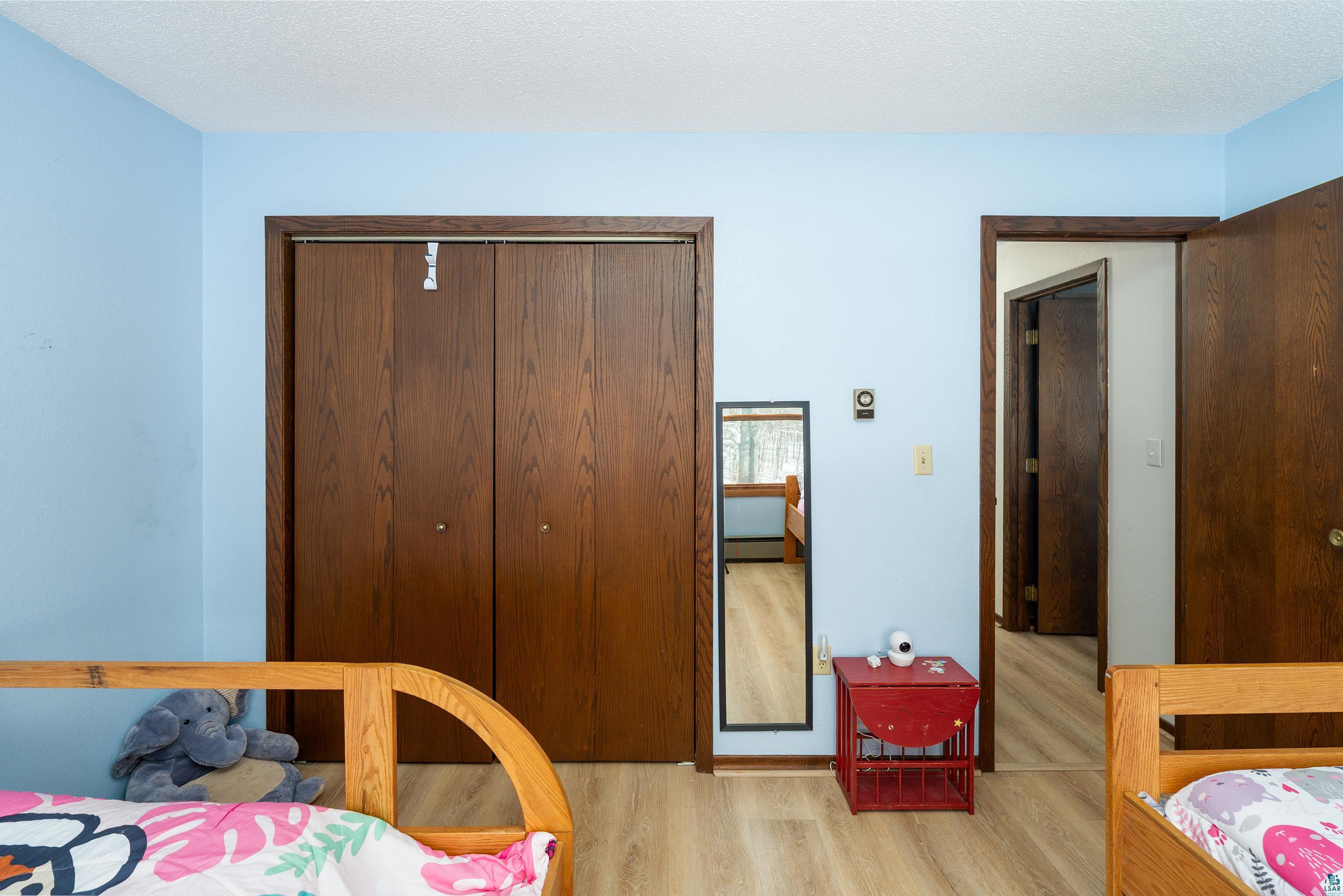 5947 East St Louis River Road Proctor, MN 55810 - Photo 23 of 47 Bedroom with a closet, light wood-type flooring, and a textured ceiling
