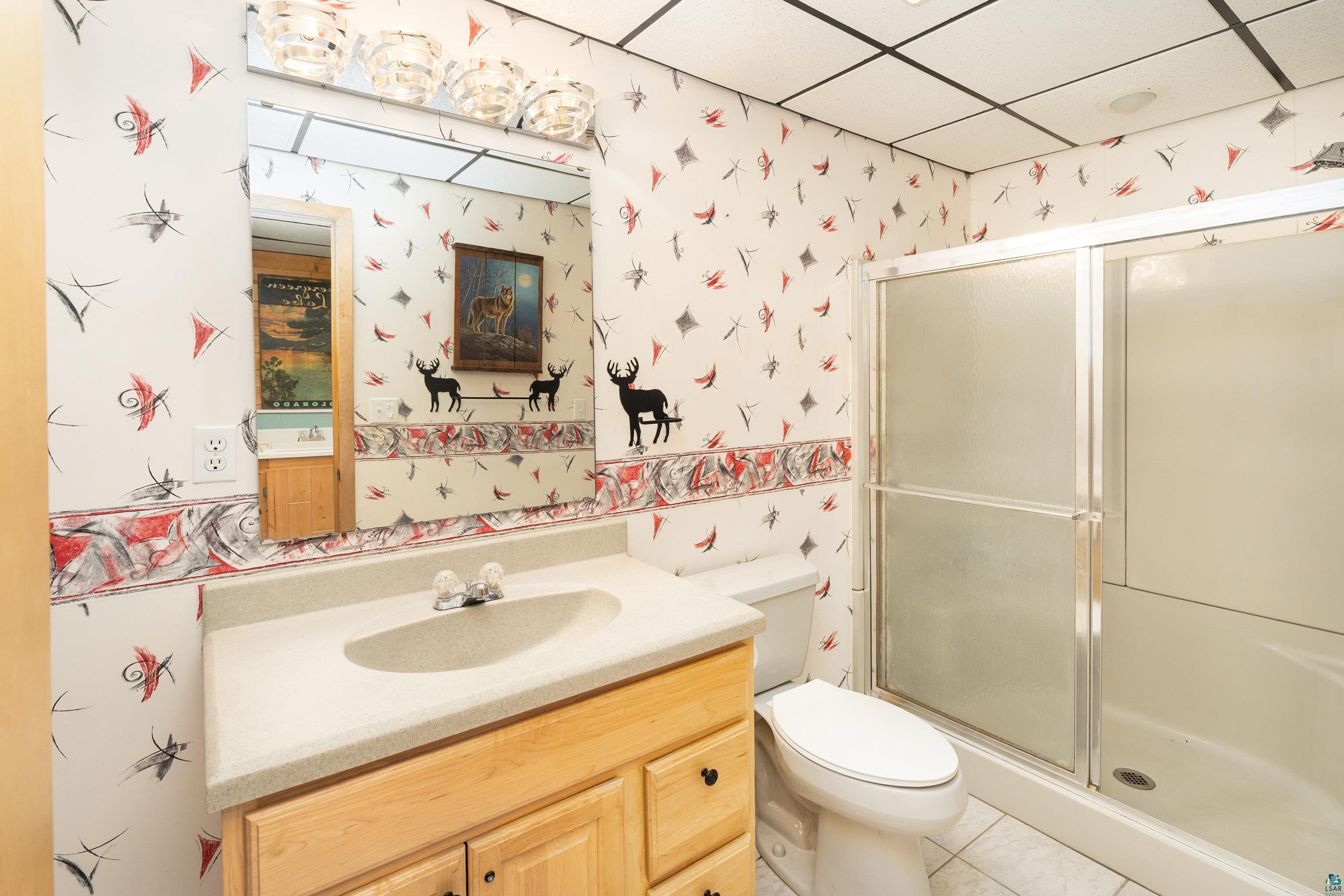 5947 East St Louis River Road Proctor, MN 55810 - Photo 28 of 47 Bathroom with vanity, a shower stall, wallpapered walls, light tile patterned floors, and a drop ceiling