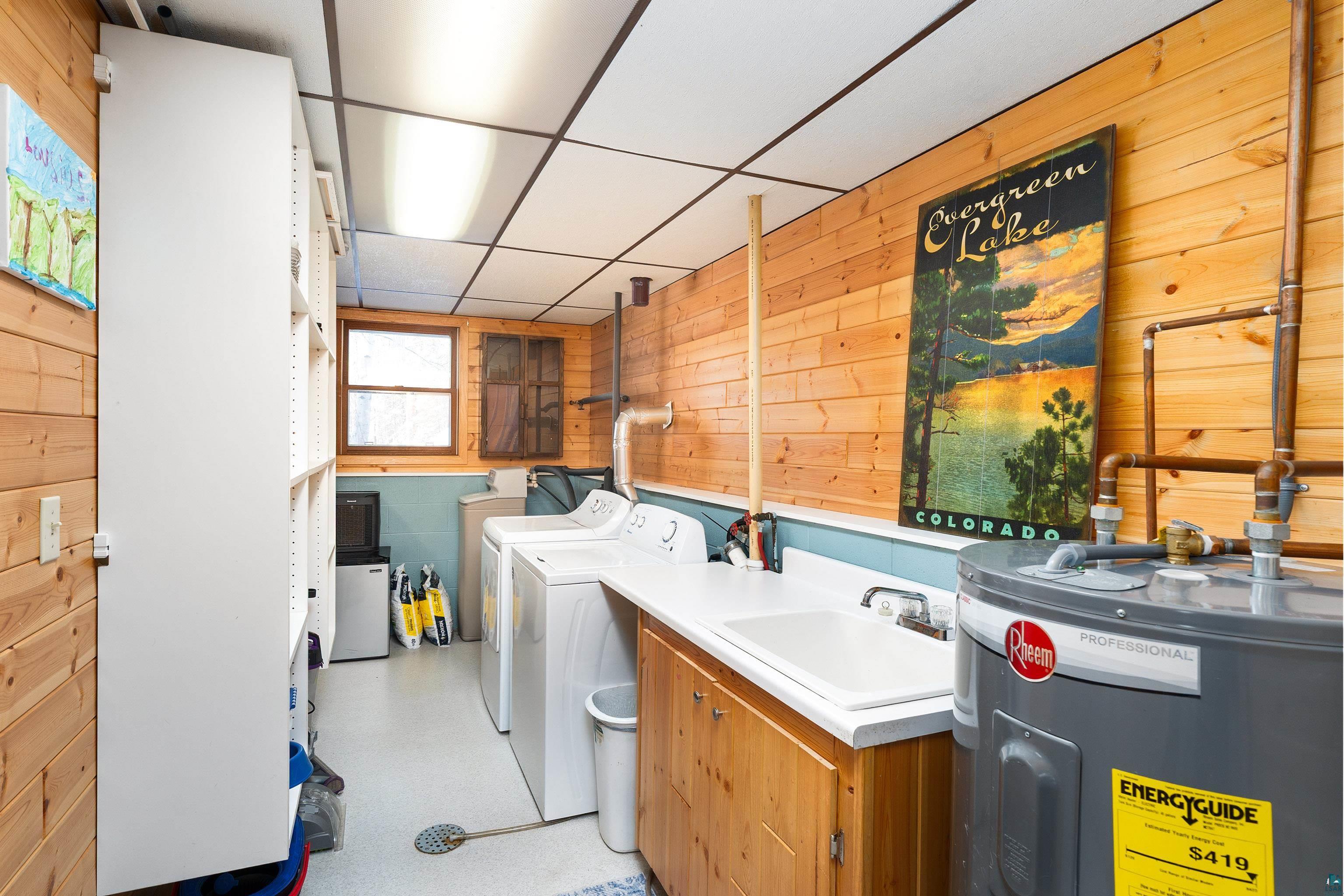 5947 East St Louis River Road Proctor, MN 55810 - Photo 30 of 47 Laundry room featuring wood walls, electric water heater, a drop ceiling, and washing machine and dryer