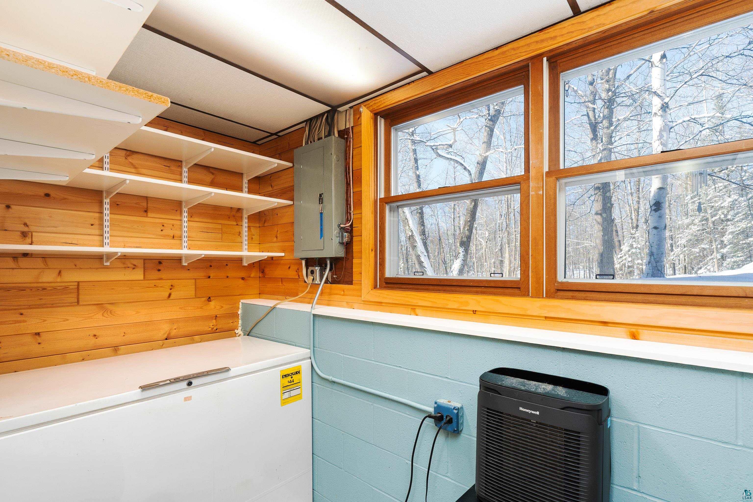 5947 East St Louis River Road Proctor, MN 55810 - Photo 31 of 47 Laundry area featuring wooden walls, electric panel, and concrete block wall