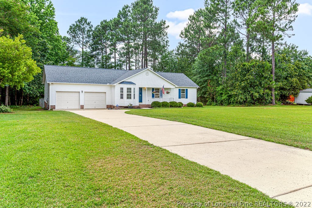 495 Sawyer Road Cameron, NC 28326 - Photo 2 of 33 a front view of a house with a garden and trees
