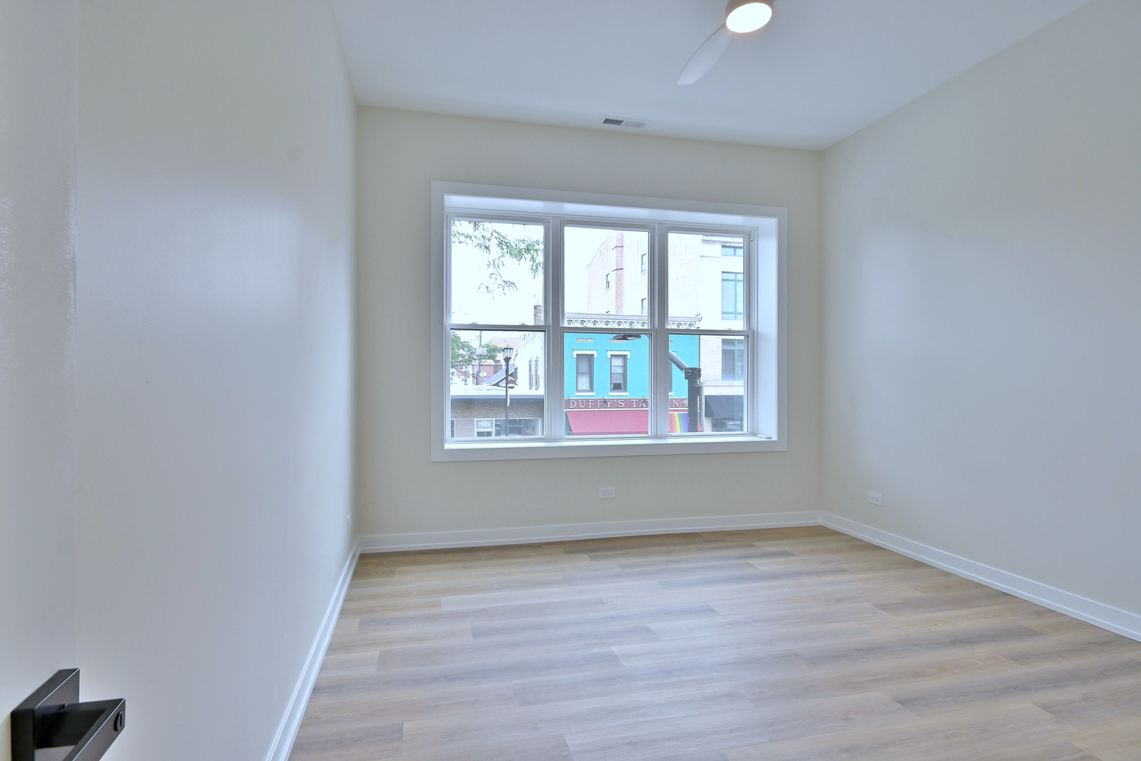 7518 Madison Street, Unit E Forest Park, IL 60130 - Photo 18 of 30 an empty room with wooden floor and windows