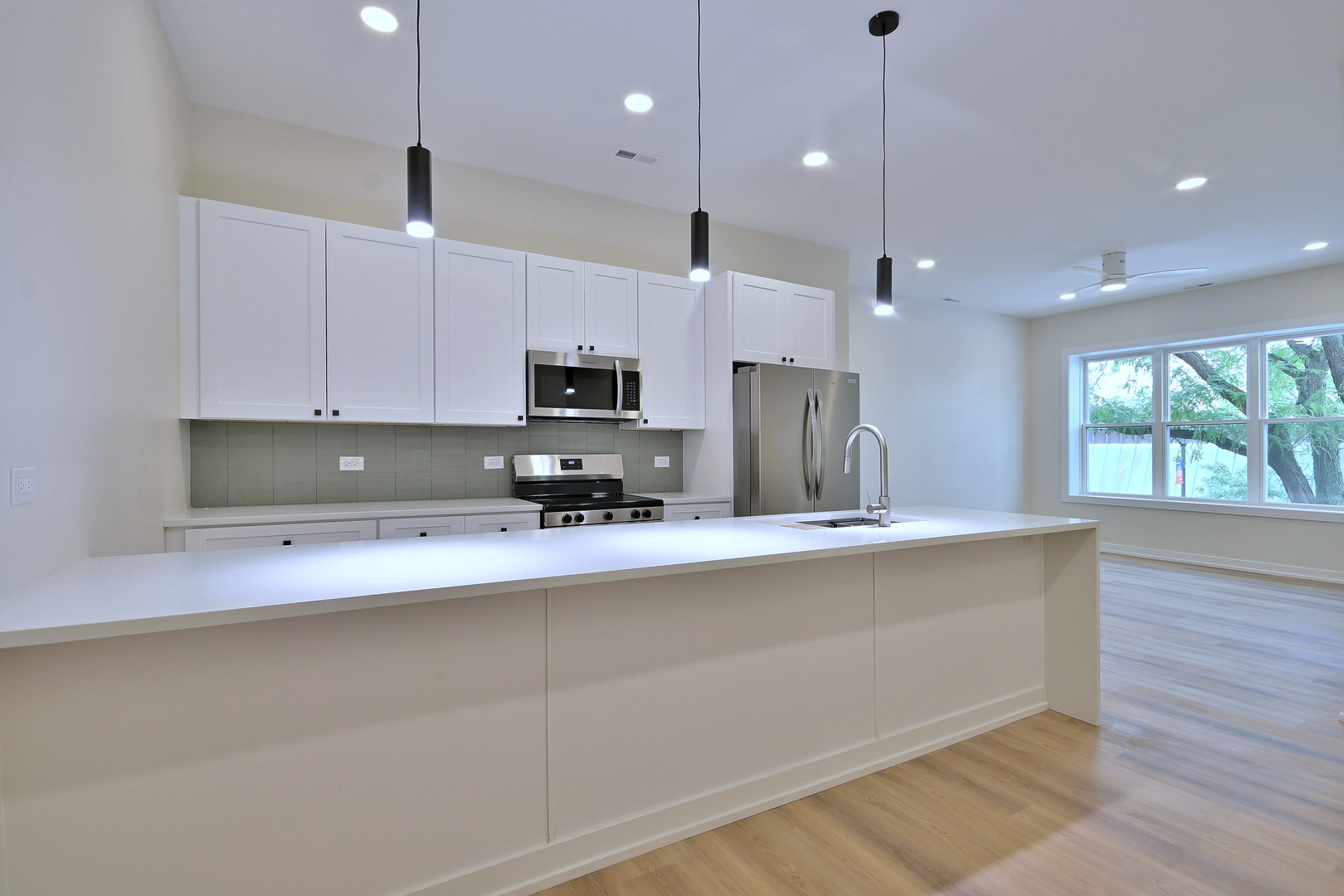 7518 Madison Street, Unit E Forest Park, IL 60130 - Photo 3 of 30 a kitchen with stainless steel appliances a microwave a sink and a counter