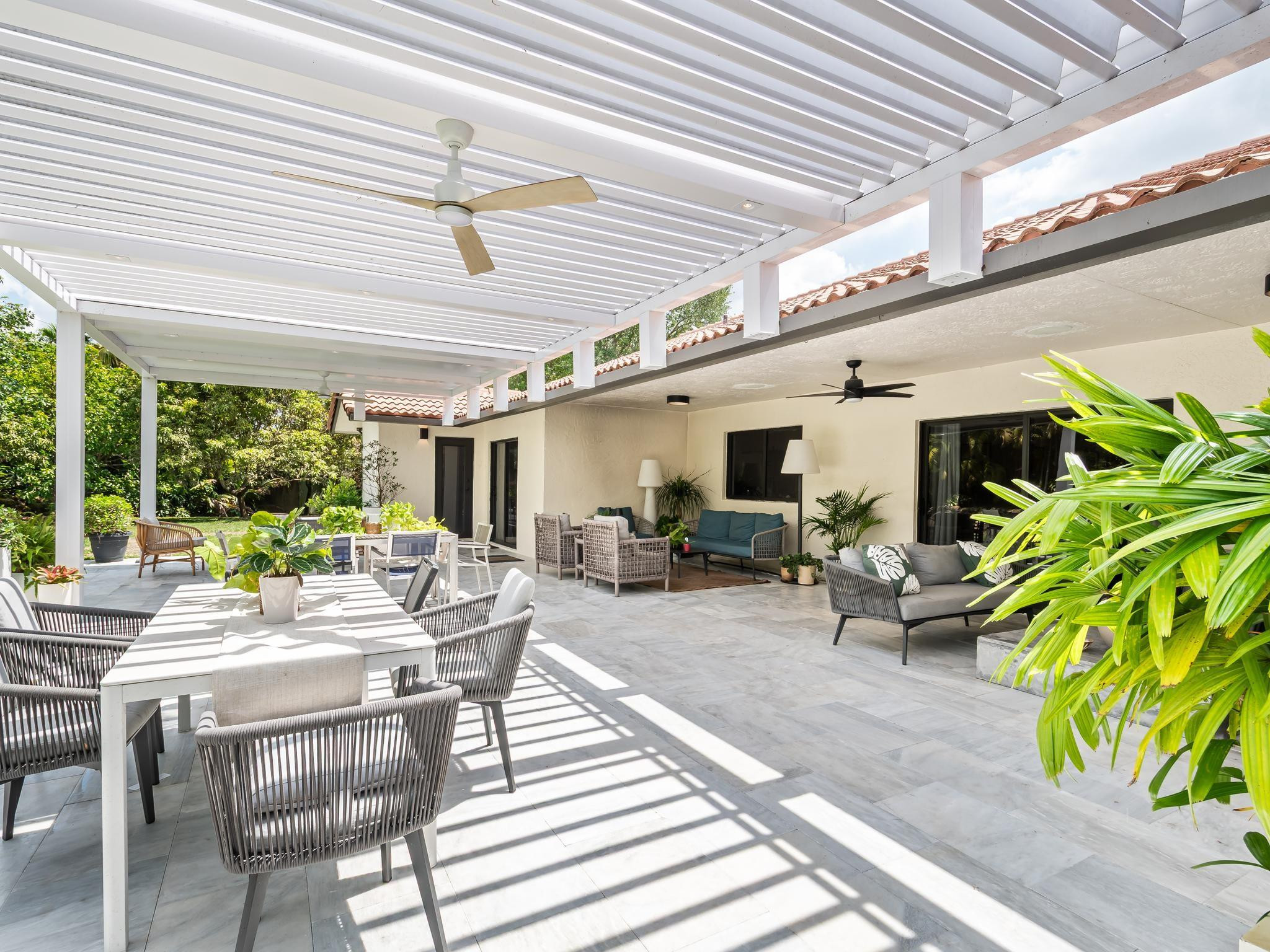 17451 Southwest 46th Street Southwest Ranches, FL 33331 - Photo 15 of 48 a view of a patio with table and chairs potted plants and large windows
