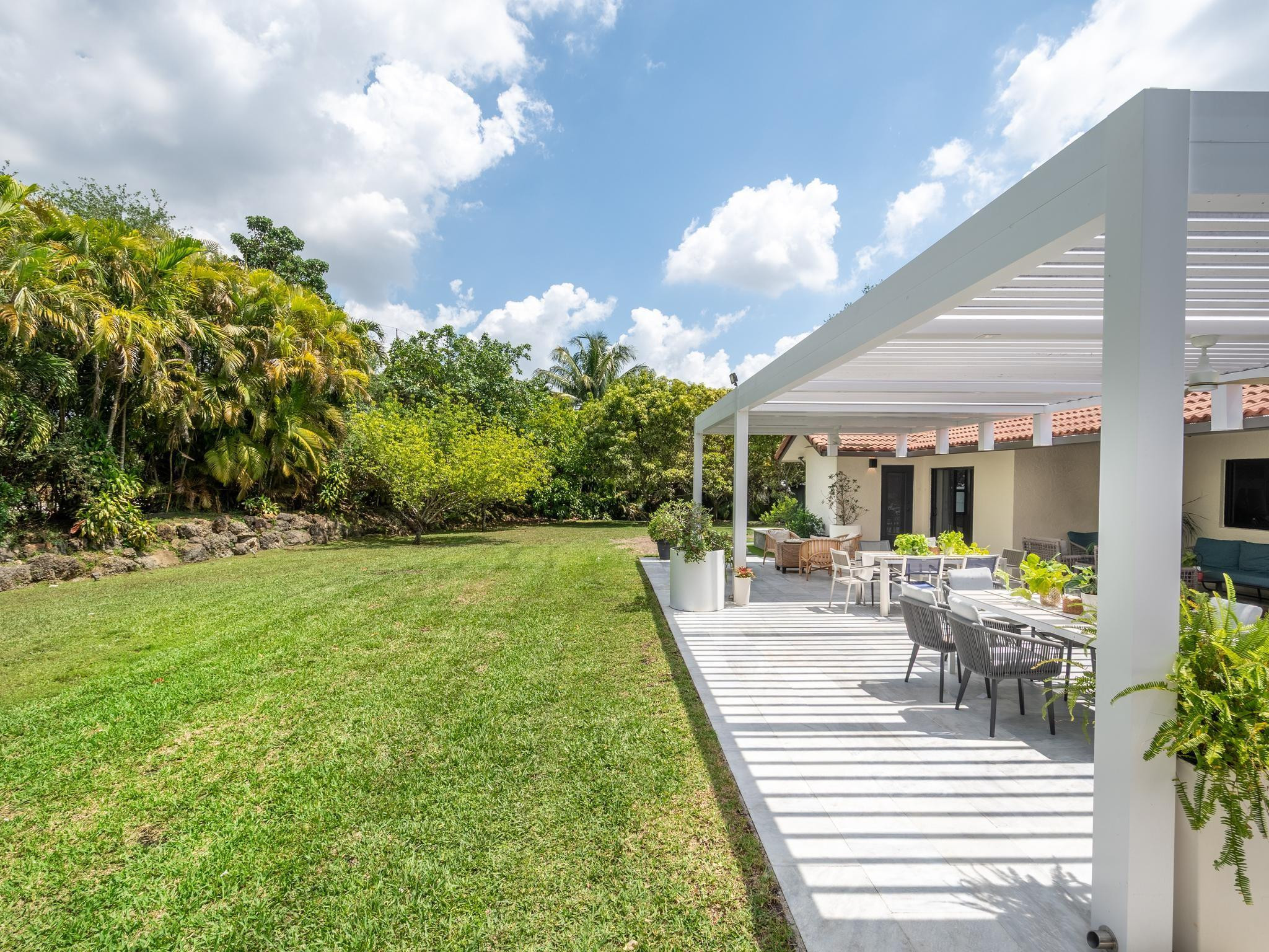 17451 Southwest 46th Street Southwest Ranches, FL 33331 - Photo 17 of 48 a view of a patio with couches and table and chairs and potted plants