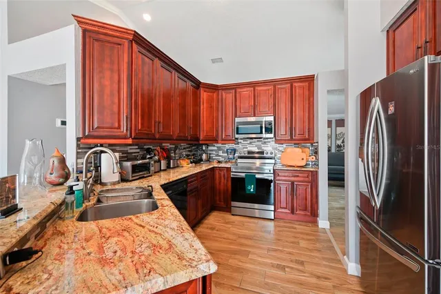 a kitchen with stainless steel appliances granite countertop a refrigerator stove and sink