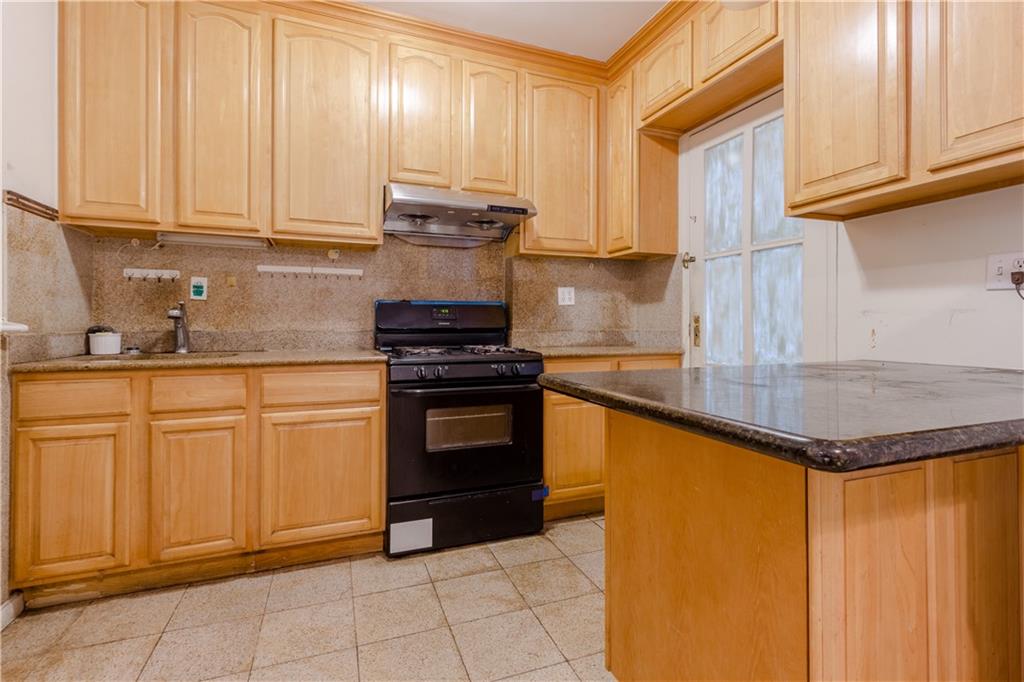 119 28th Avenue Brooklyn, NY 11214 - Photo 3 of 7 a kitchen with stainless steel appliances granite countertop a sink and cabinets