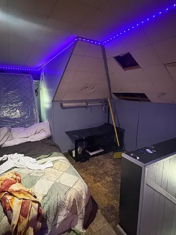 a bed sitting in a bedroom next to a lamp